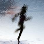 A blurred image of a person running at the beach.