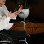 woman in wheelchair using smartphone